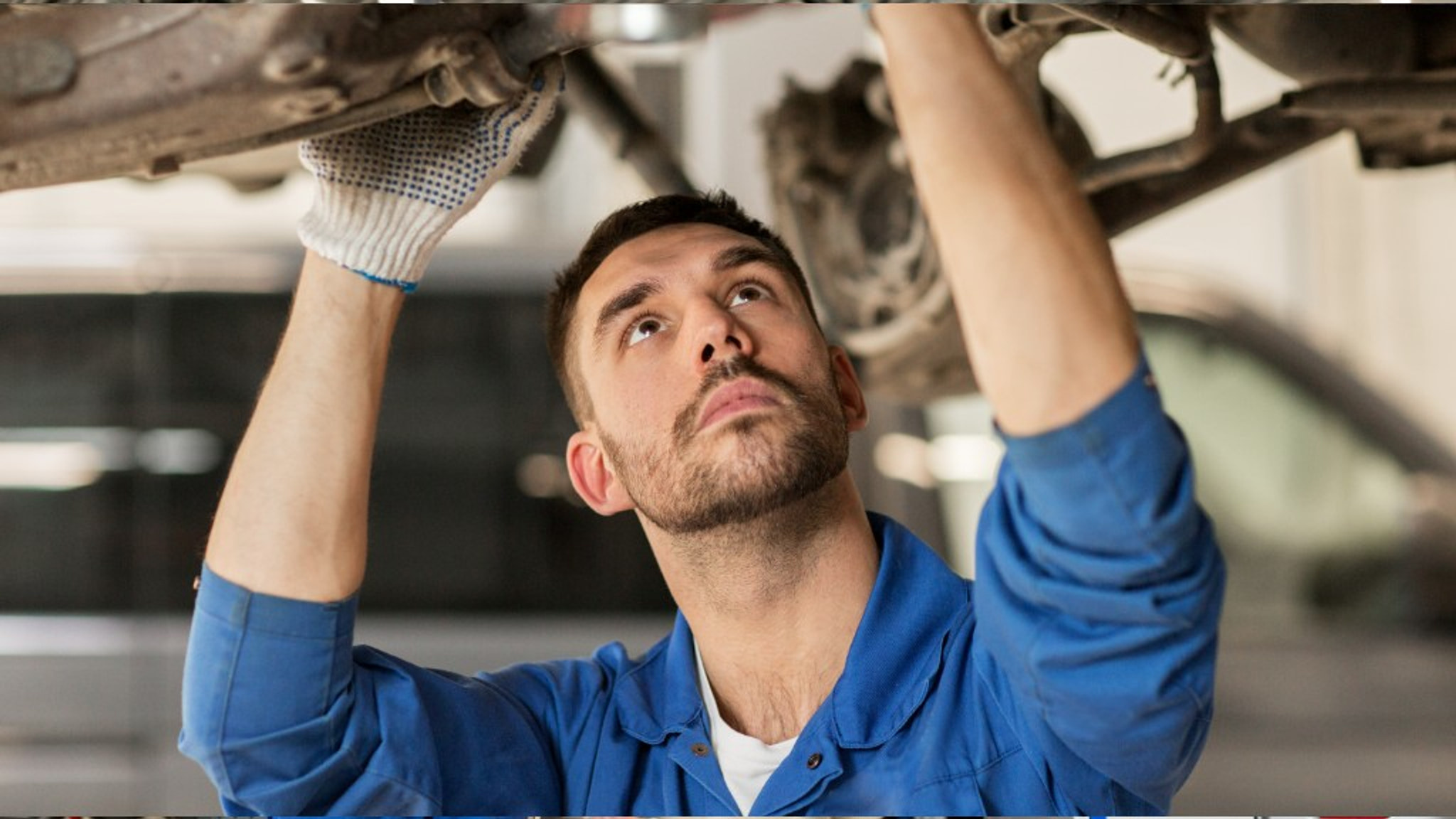 Euro Car Centre mechanic working on a car raised on a workshop lift