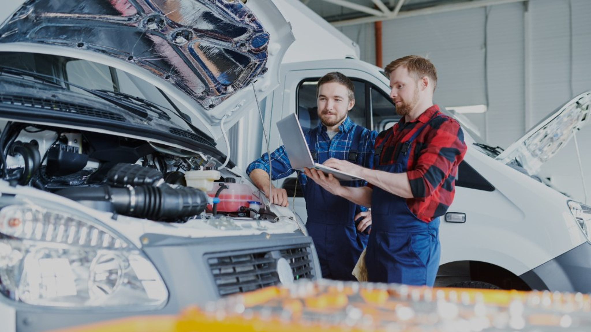 Euro Car Centre technicians using diagnostic equipment on a van with the bonnet open