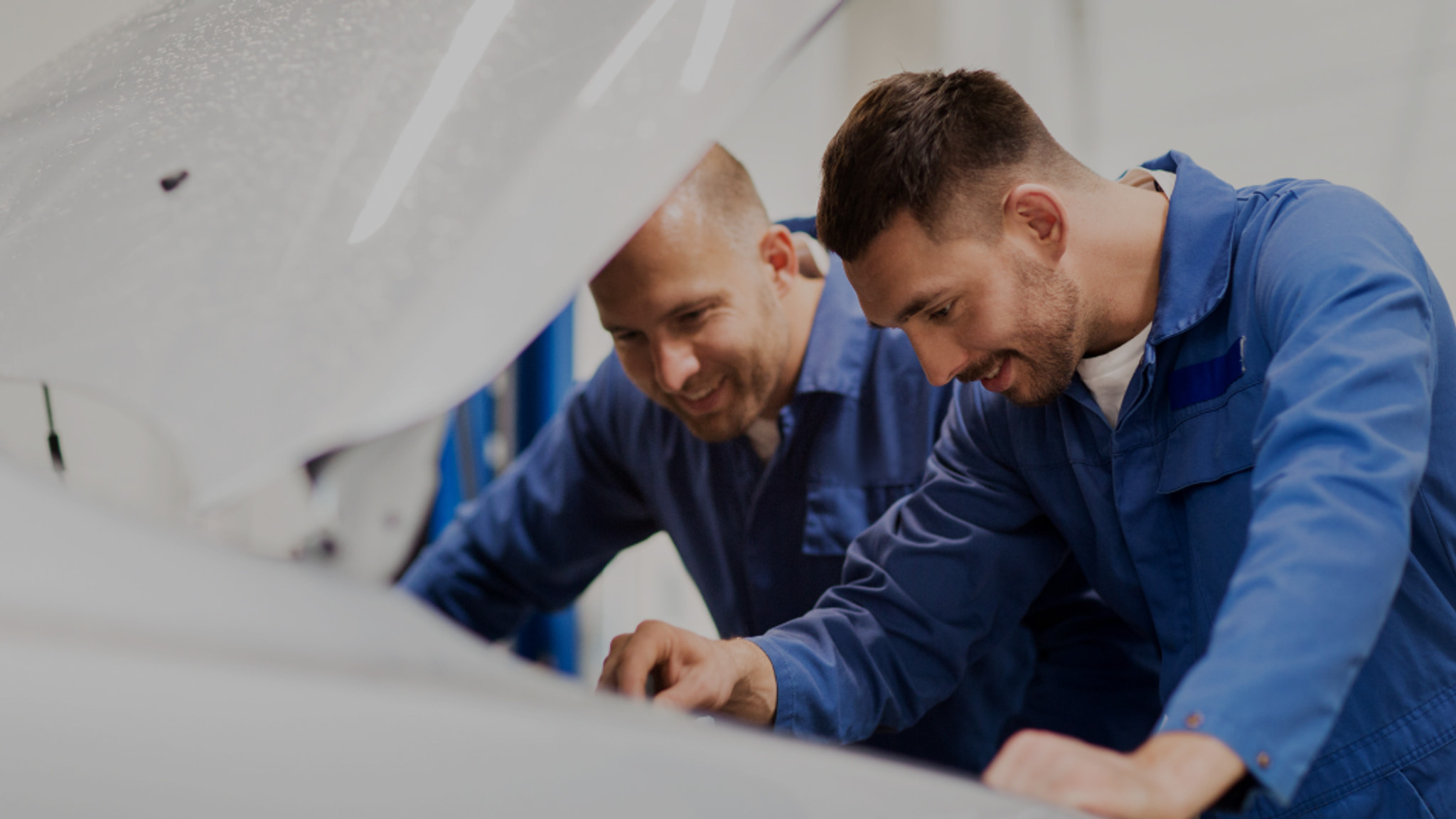 Two mechanics inspecting an engine bay at Euro Car Centre